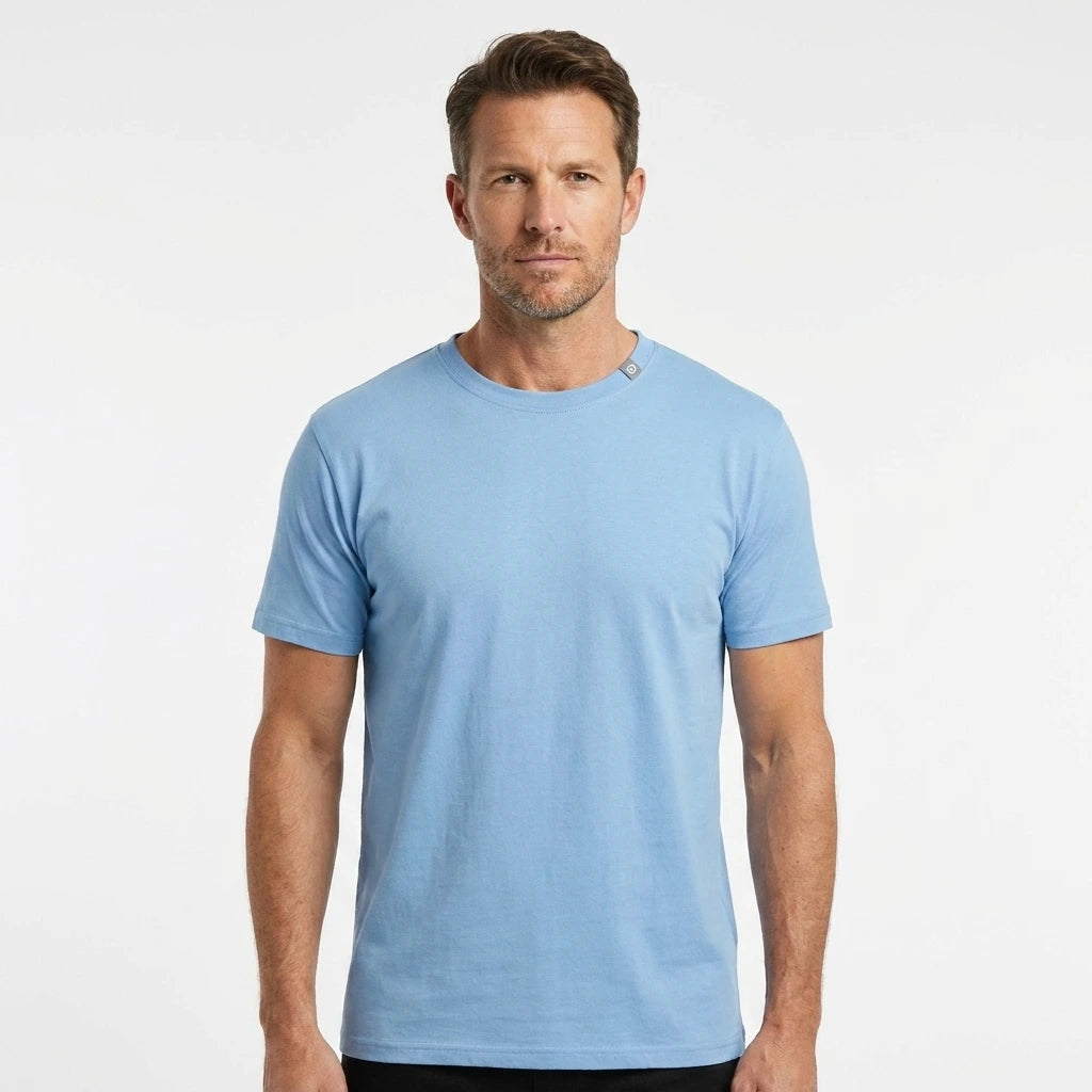 T-Time T-shirt, Lys Blå 0510 | Studio portrait of a 45-year-old man, athletic build, short brown hair, light stubble, neutral confident expression, standing against a plain white seamless stu