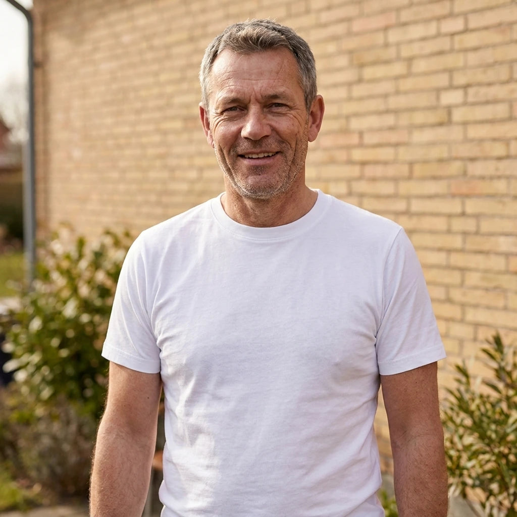 Basic T-shirt, Hvid - 2000 | Livsstilsfoto af en veltrænet mand omkring 55 år med kortklippet gråt/salt-og-peber hår og skægstubbe, iført en almindelig hvid rundhalset T-shirt uden tryk.