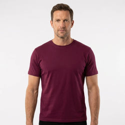 T-Time T-shirt, Bordeaux 0510 | Studio portrait of a 45-year-old man, athletic build, short brown hair, light stubble, neutral confident expression, standing against a plain white seamless stu
