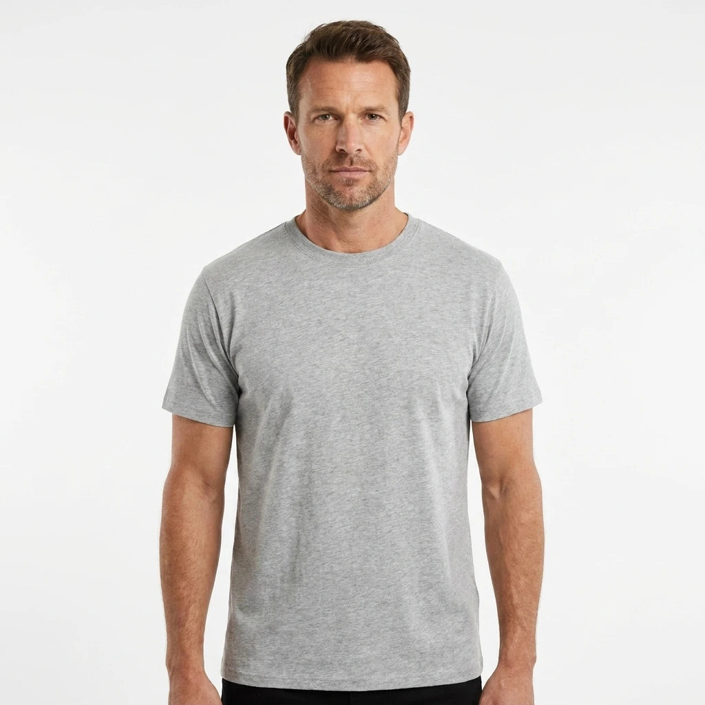 T-Time T-shirt, Grå melange 0510 | Studio portrait of a 45-year-old man, athletic build, short brown hair, light stubble, neutral confident expression, standing against a plain white seamless stu