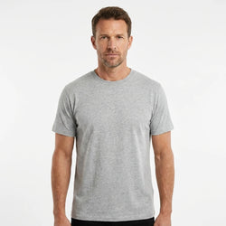 T-Time T-shirt, Grå melange 0510 | Studio portrait of a 45-year-old man, athletic build, short brown hair, light stubble, neutral confident expression, standing against a plain white seamless stu