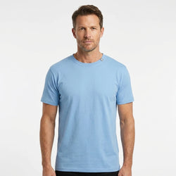 T-Time T-shirt, Lys Blå 0510 | Studio portrait of a 45-year-old man, athletic build, short brown hair, light stubble, neutral confident expression, standing against a plain white seamless stu