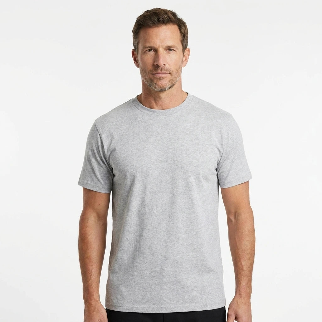 T-Time T-shirt, Snow Melange 0510 | Studio portrait of a 45-year-old man, athletic build, short brown hair, light stubble, neutral confident expression, standing against a plain white seamless stu
