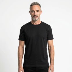 T-Time T-shirt, Sort 0510 | Studio portrait of a 45-year-old man, athletic build, short brown hair, light stubble, neutral confident expression, standing against a plain white seamless stu